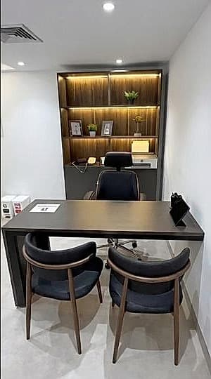 Consultorio del Dr. Barreto, con escritorio y sillas para el paciente